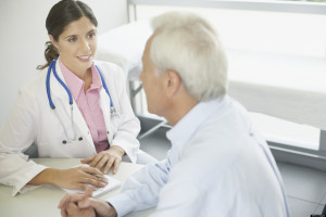 Doctor sitting in office with patient talking and smiling